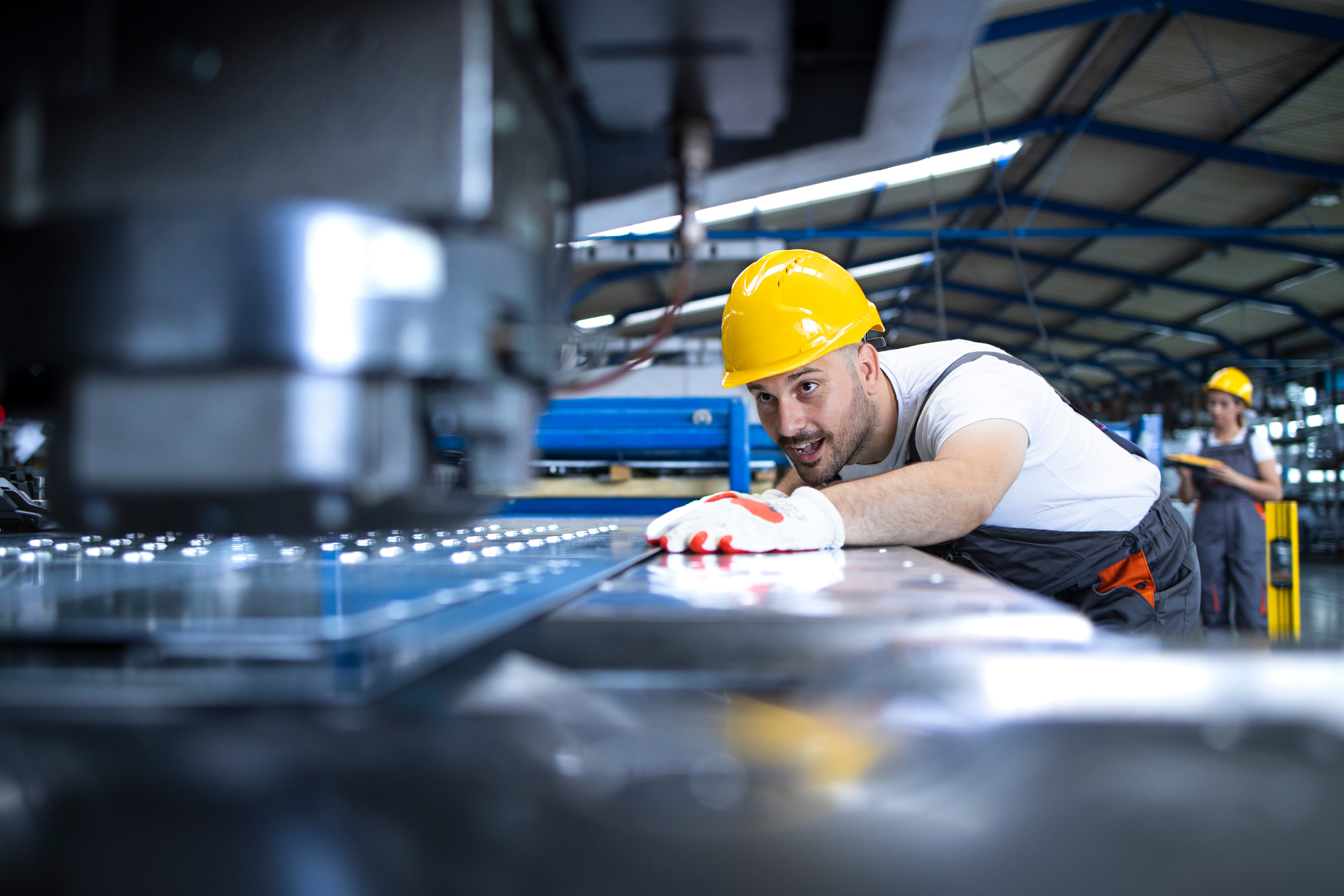 People working in factory. Operating industrial machine.